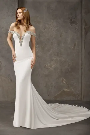 Off-shoulder mermaid wedding dress made entirely in crepe with sparkling gemstone embellishments at the neckline and off-shoulder sleeves.